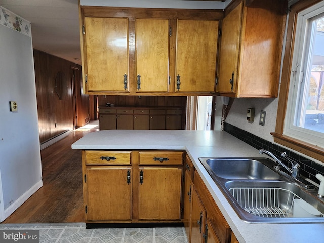 kitchen with baseboard heating, kitchen peninsula, and sink