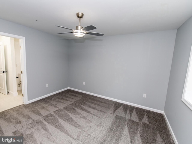 spare room featuring ceiling fan, carpet flooring, and baseboards