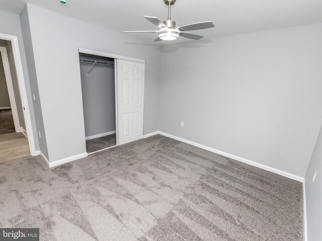 unfurnished bedroom with a closet, carpet flooring, a ceiling fan, and baseboards