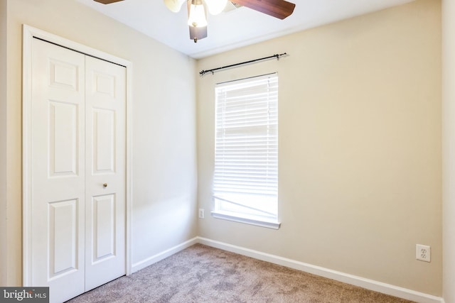 unfurnished bedroom with light carpet, a closet, and ceiling fan