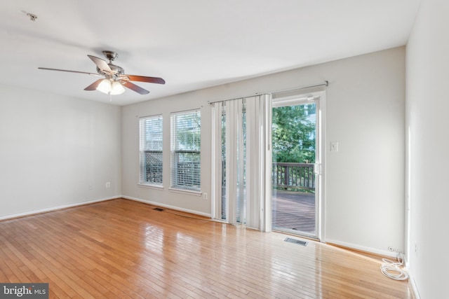 spare room with plenty of natural light, ceiling fan, and light hardwood / wood-style flooring