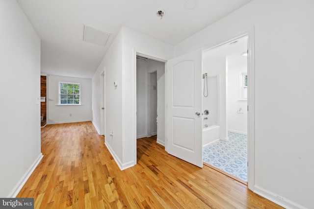 corridor with light hardwood / wood-style floors