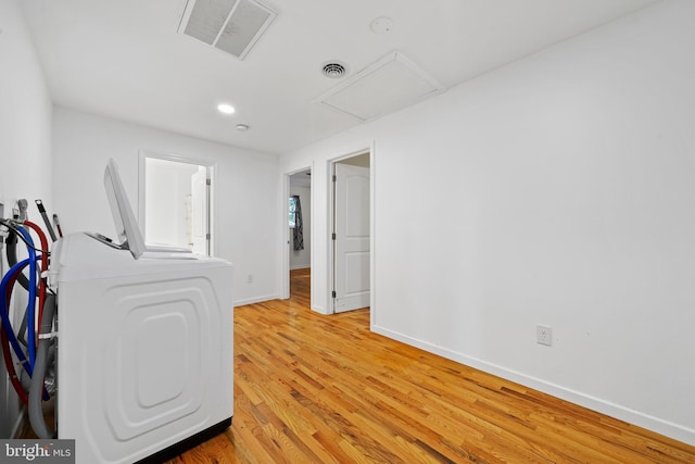 clothes washing area featuring light hardwood / wood-style floors and washer / dryer