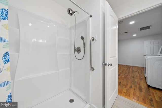 bathroom featuring separate washer and dryer, hardwood / wood-style floors, and a shower with shower curtain