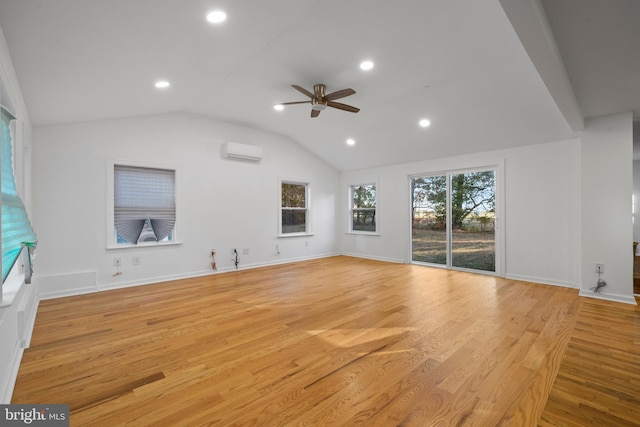 unfurnished living room with a wall mounted air conditioner, ceiling fan, light wood-type flooring, and lofted ceiling