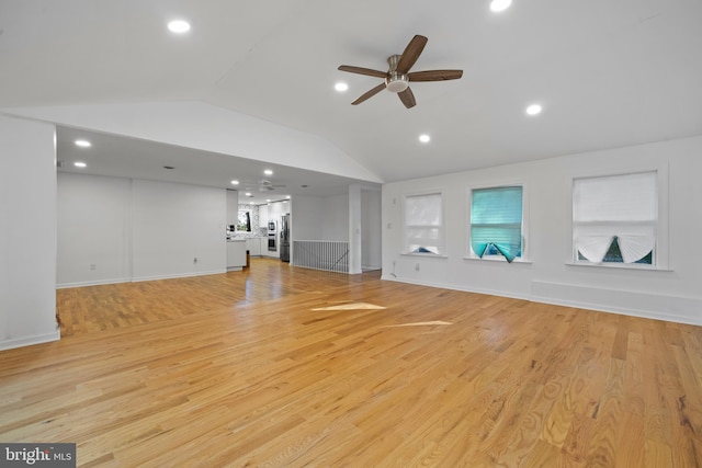 unfurnished living room with ceiling fan, vaulted ceiling, and light wood-type flooring