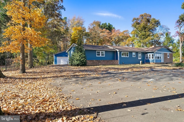 ranch-style house featuring a garage and an outbuilding