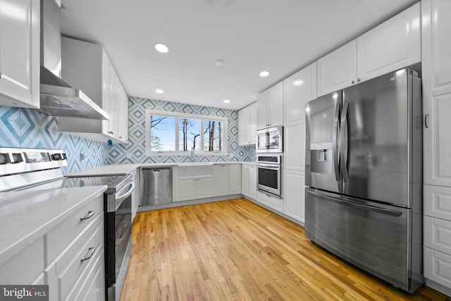 kitchen featuring stainless steel appliances, white cabinetry, and tasteful backsplash