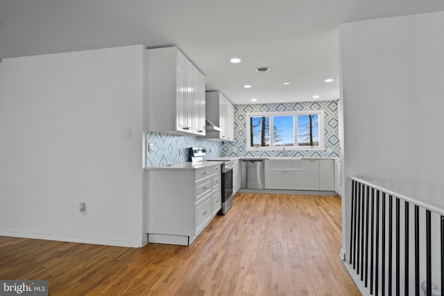 kitchen with light hardwood / wood-style floors, sink, white cabinetry, and stainless steel appliances