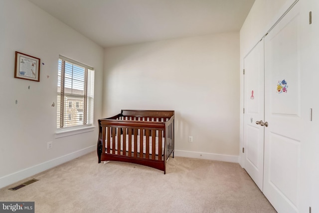 carpeted bedroom with a nursery area