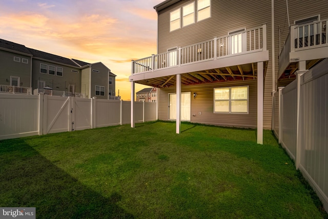 back house at dusk featuring a yard