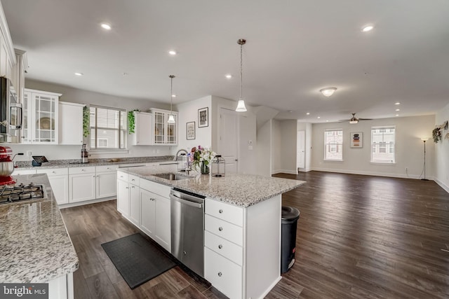 kitchen featuring a center island with sink, appliances with stainless steel finishes, pendant lighting, white cabinets, and sink