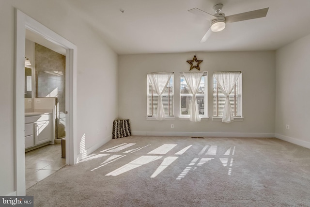 spare room with ceiling fan and light colored carpet