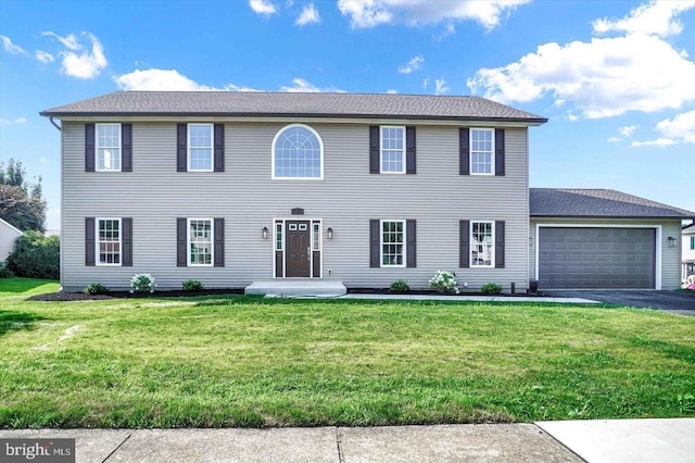 colonial-style house with a front yard and a garage