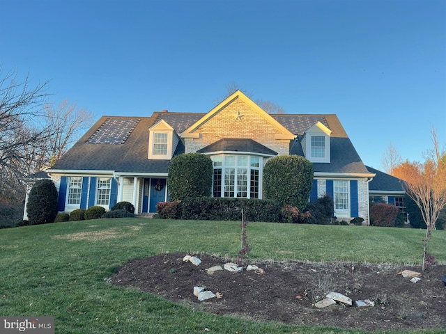 cape cod-style house with a front lawn