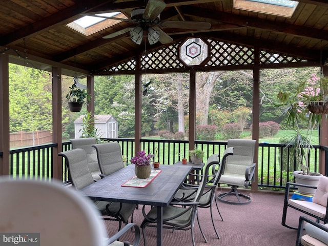 wooden terrace with a lawn, ceiling fan, a gazebo, and a shed