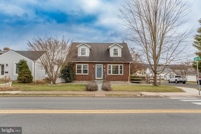 new england style home featuring a front yard