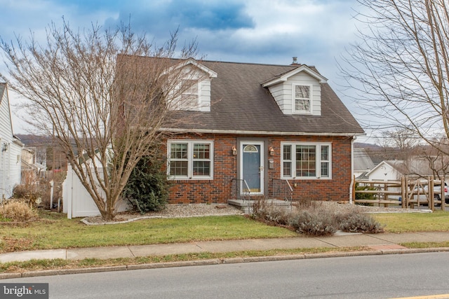 cape cod home with a front yard