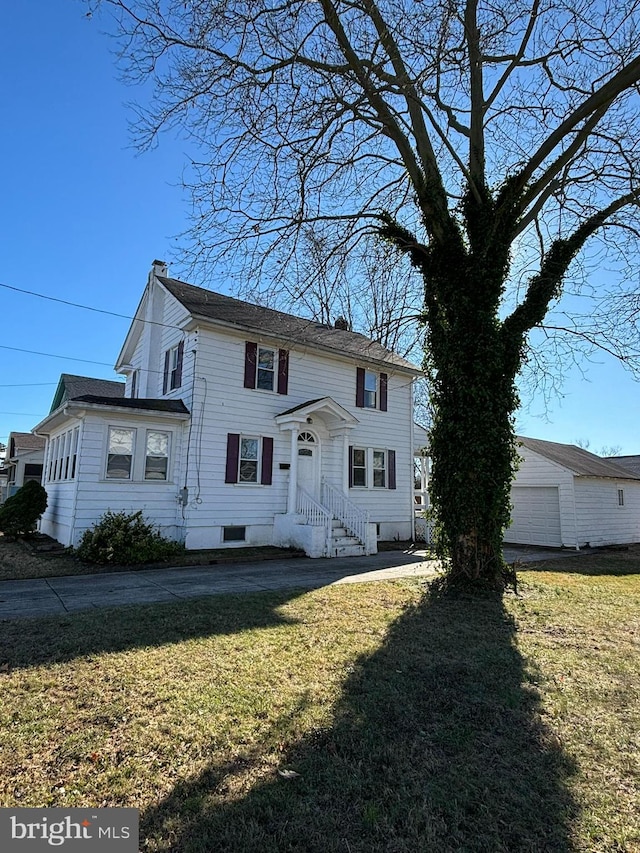 view of front of home with an outbuilding and a front yard