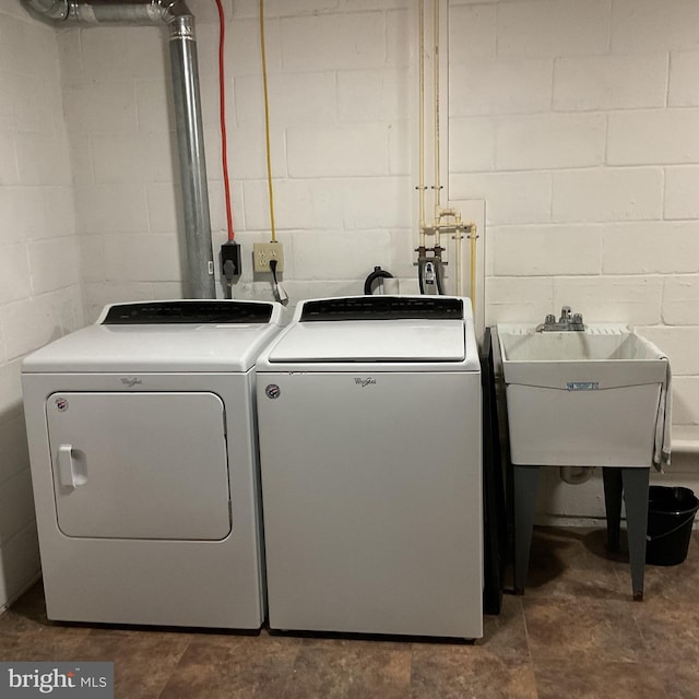 clothes washing area featuring sink and washing machine and clothes dryer