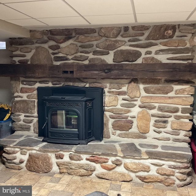 room details with a paneled ceiling and a wood stove