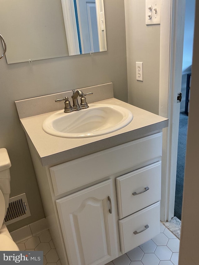 bathroom with vanity, toilet, and tile patterned flooring