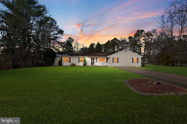 ranch-style home with a yard