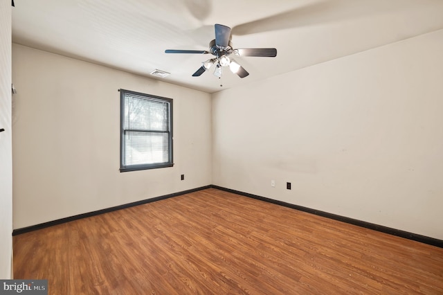 spare room with hardwood / wood-style floors and ceiling fan