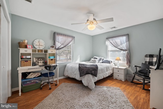 bedroom with multiple windows, hardwood / wood-style floors, a closet, and ceiling fan