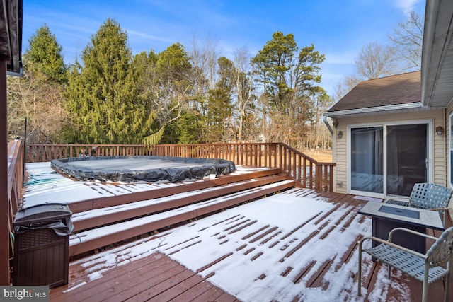 snow covered deck featuring a jacuzzi and an outdoor fire pit