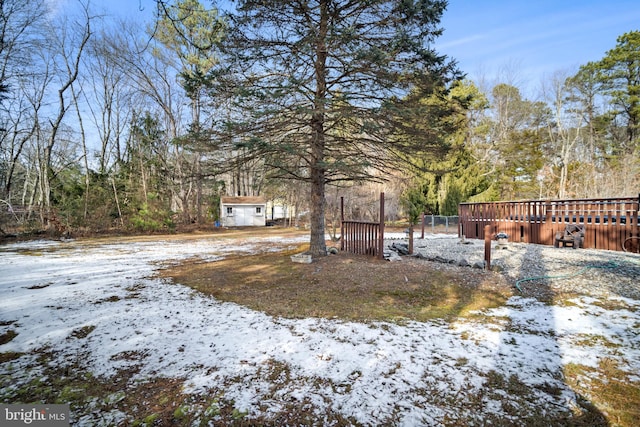 snowy yard featuring a storage shed