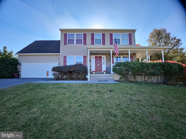 view of front of house with a garage, a front lawn, and covered porch