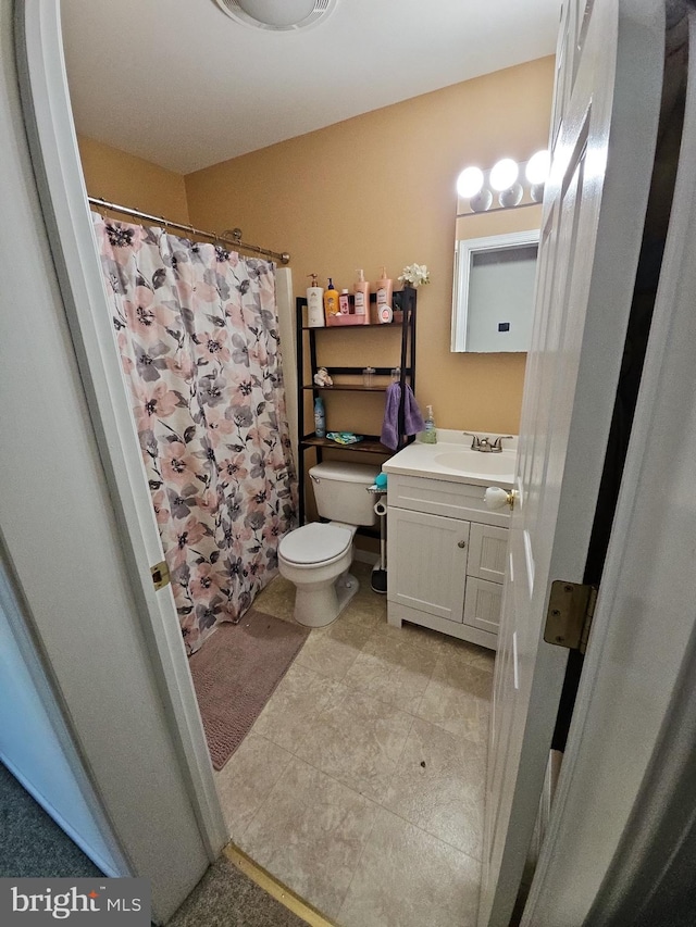 bathroom featuring vanity, toilet, and a shower with shower curtain