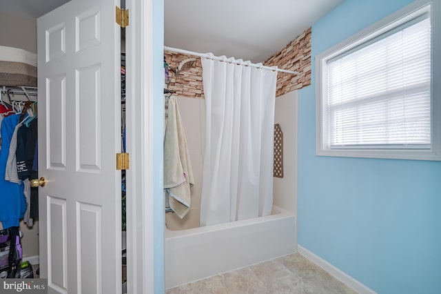 bathroom featuring shower / bathtub combination with curtain and tile patterned flooring