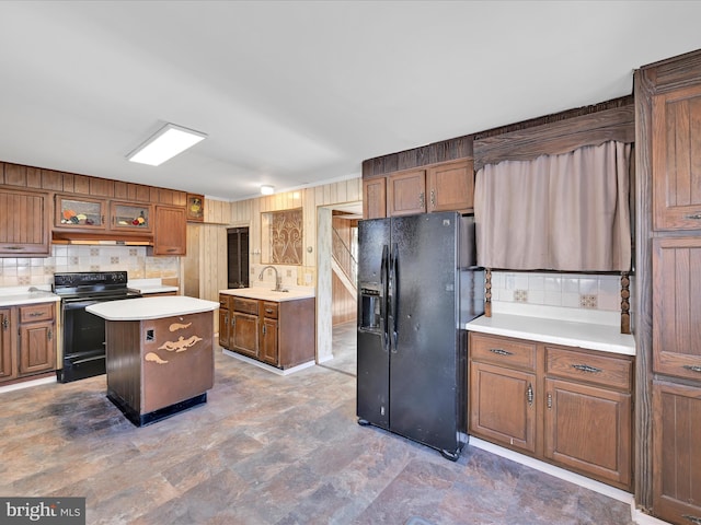 kitchen with backsplash, sink, a kitchen island, and black appliances