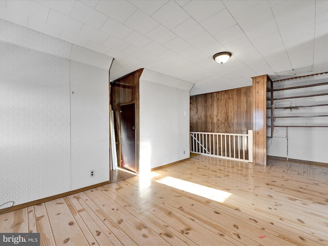 spare room with wooden walls and light hardwood / wood-style flooring