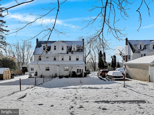 view of snow covered back of property