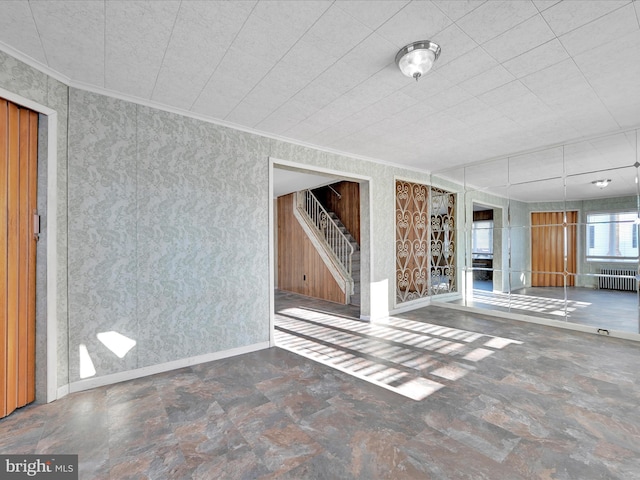 unfurnished living room featuring crown molding and radiator