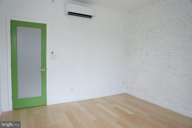 unfurnished room with hardwood / wood-style floors and a wall unit AC