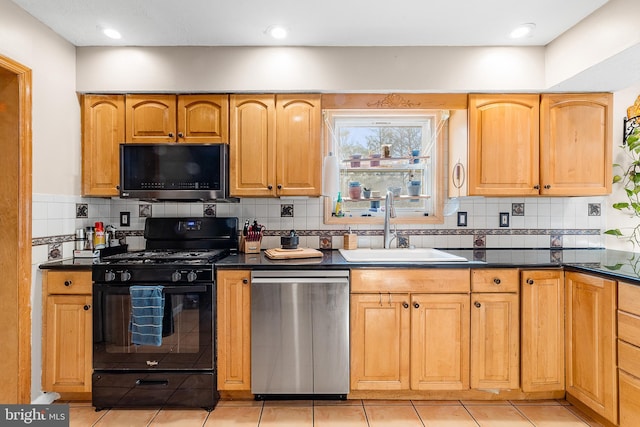 kitchen featuring sink, backsplash, light tile patterned floors, and appliances with stainless steel finishes