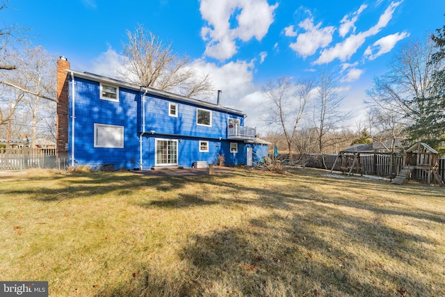 rear view of house featuring a yard and a playground