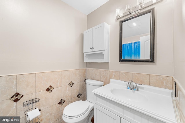 bathroom featuring tile walls, vanity, and toilet