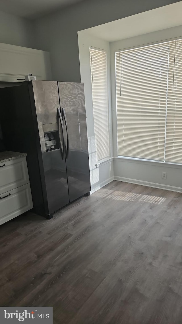 kitchen featuring stainless steel fridge with ice dispenser, hardwood / wood-style floors, and white cabinets