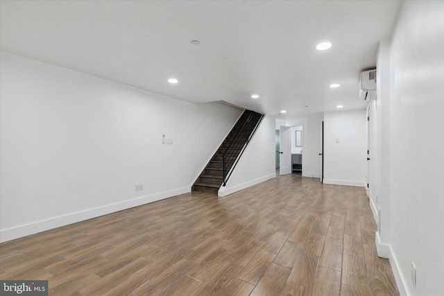 interior space with hardwood / wood-style flooring and a wall unit AC