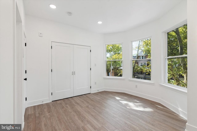 unfurnished bedroom featuring a closet and light hardwood / wood-style flooring