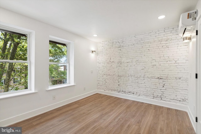 empty room featuring hardwood / wood-style flooring and an AC wall unit