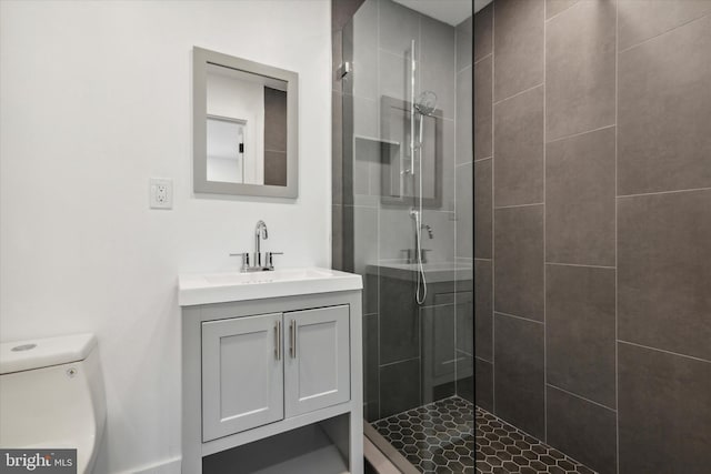 bathroom with tiled shower, vanity, and toilet