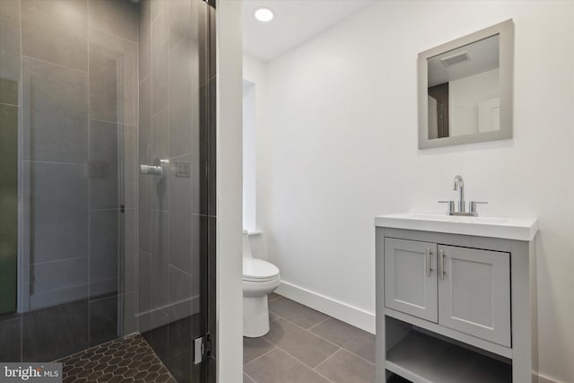 bathroom with tile patterned floors, vanity, toilet, and a shower with door