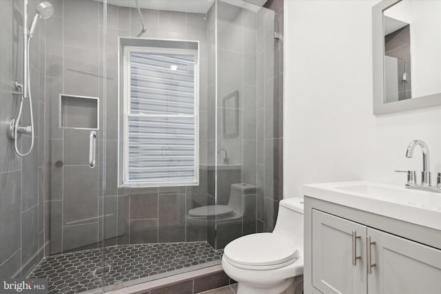 bathroom with tile patterned flooring, vanity, an enclosed shower, and toilet