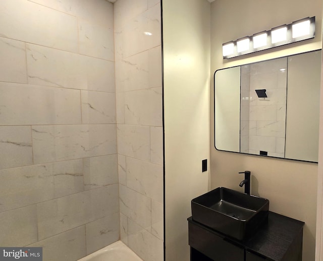 bathroom featuring tiled shower / bath combo and vanity